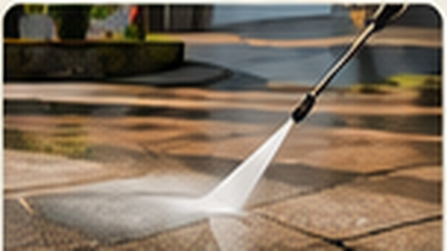 Pressure washer cleaning a paved driveway